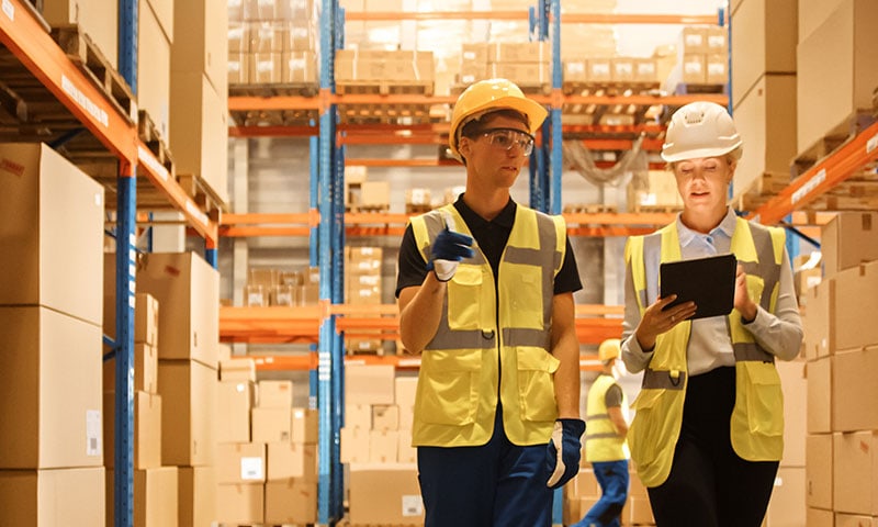 Prestataires logistiques dans l’entrepôt contrôlant les stocks avec le logiciel de gestion d'entrepôt